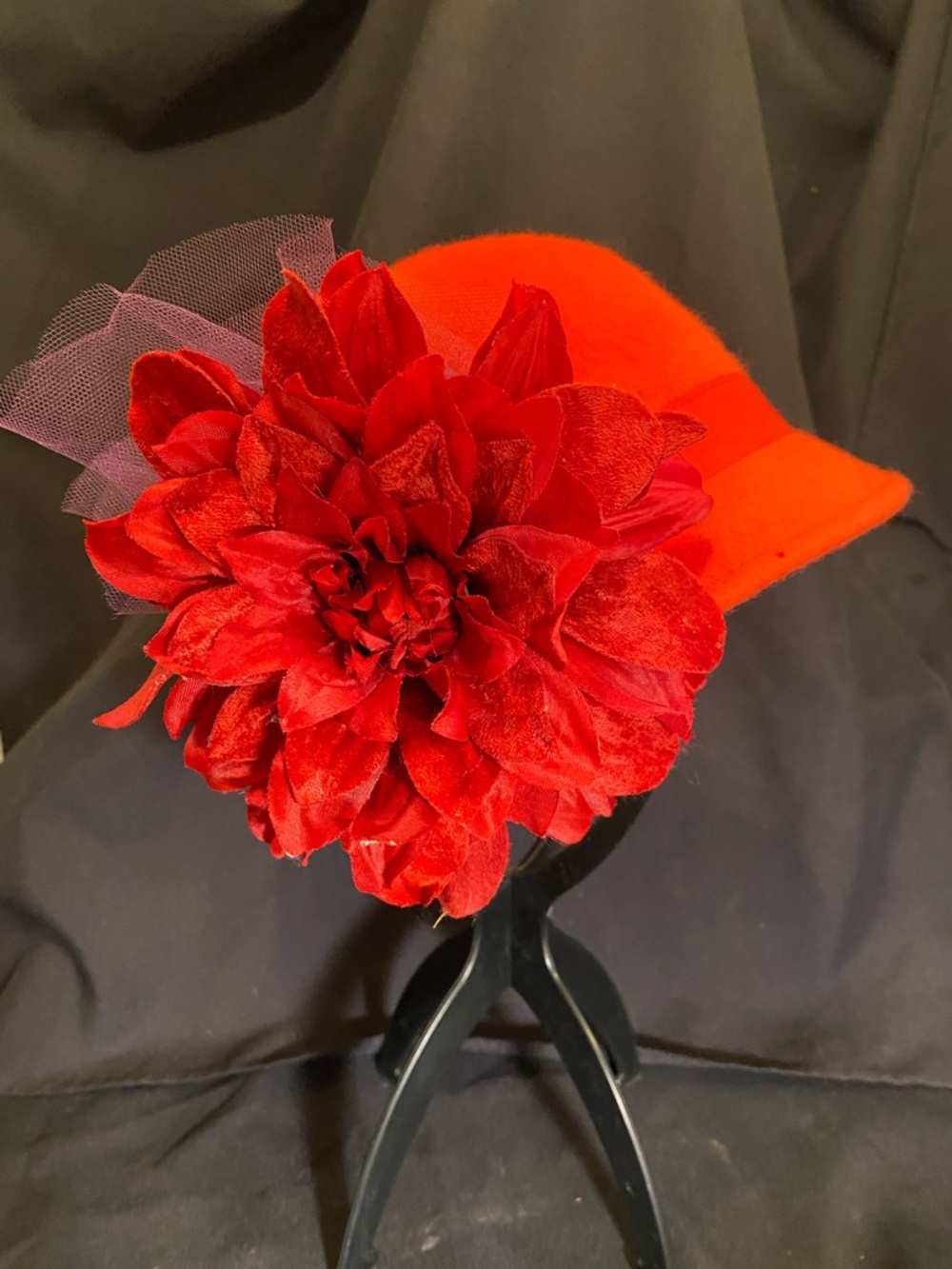 Vintage-style red wool felt cloche hat decorated with a flower and mesh net.